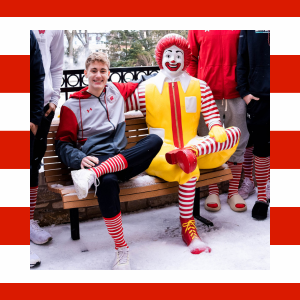 Isaac Gard A boy wearing striped socks sitting next to a Ronald McDonald Statue
